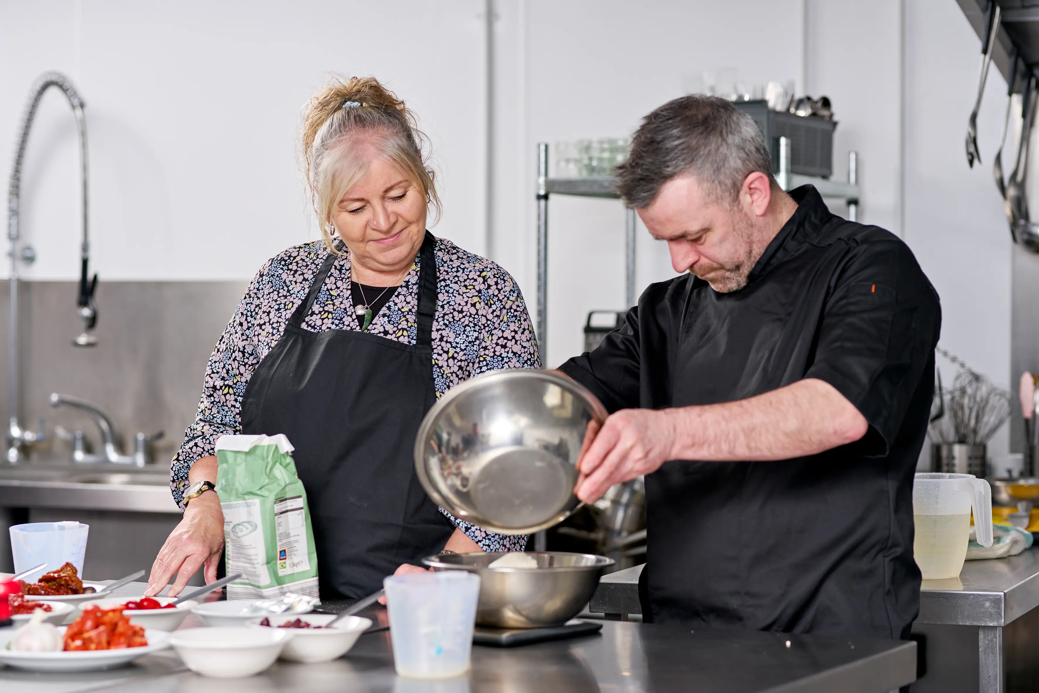 Community Kitchen chef Chris teaching a member how to make bread