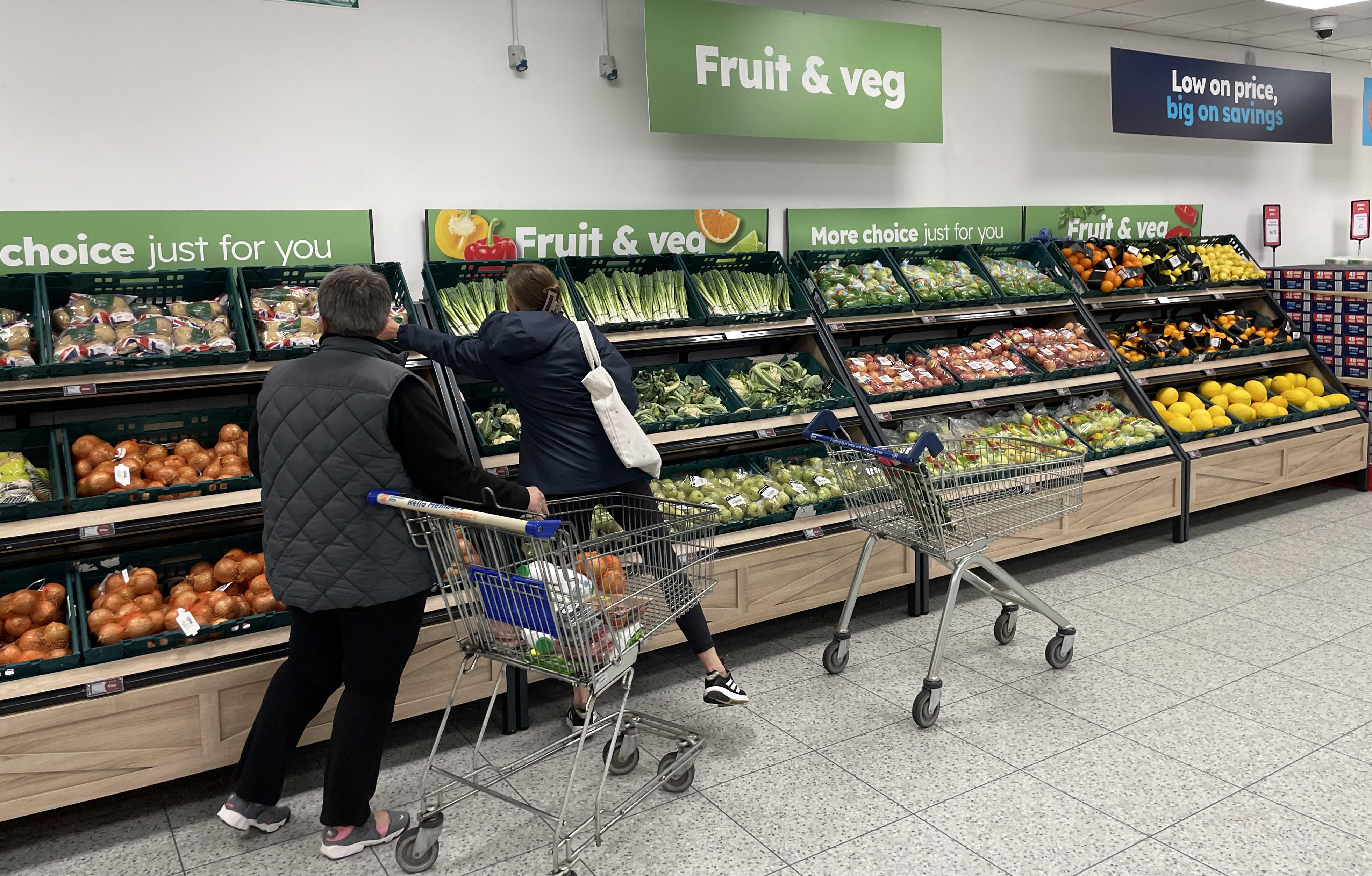 Shoppers are choosing from surplus fruit and veg in a discount supermarket.