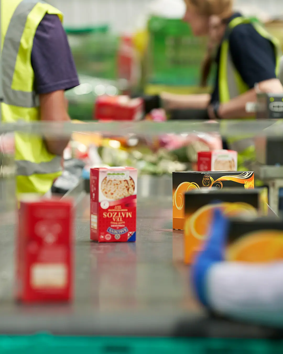 Surplus warehouse conveyor belt with boxes of surplus tea and rice cakes.