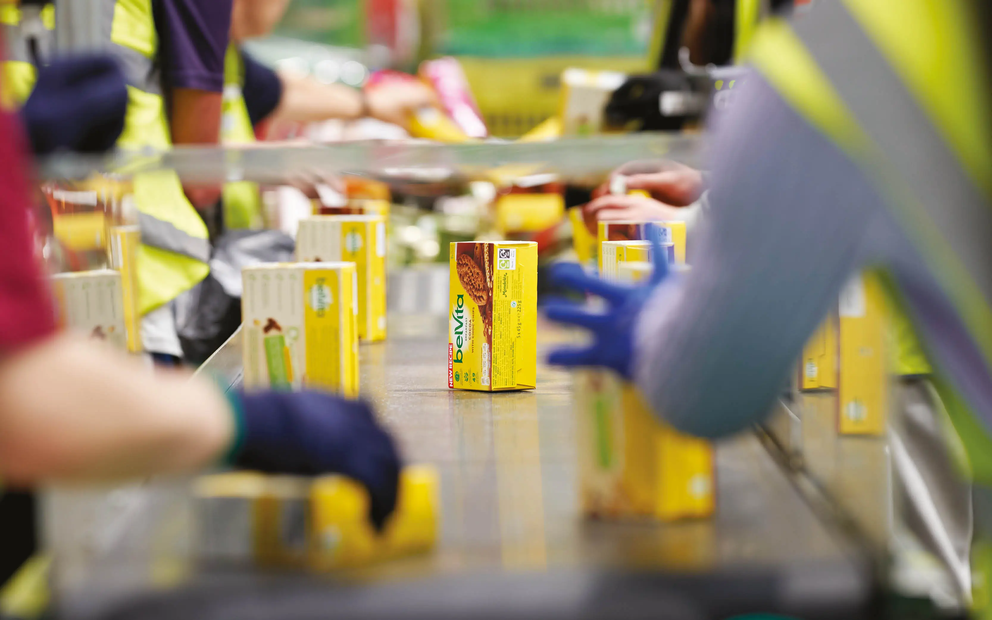 Bright yellow boxes of surplus breakfast biscuits are being moved along a conveyor belt.