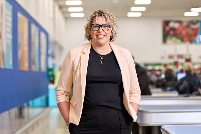 Gemma Edlin, Retail Director, stands in a brightly lit Company Shop.
